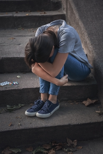 woman sitting on steps after using drugs