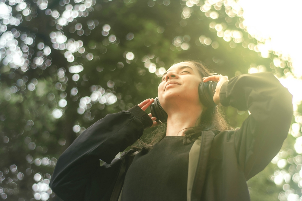 woman listening to music in headphones looking up