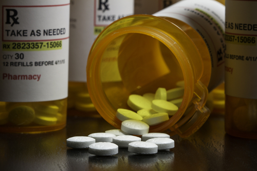 pills spilling out of a bottle onto the table