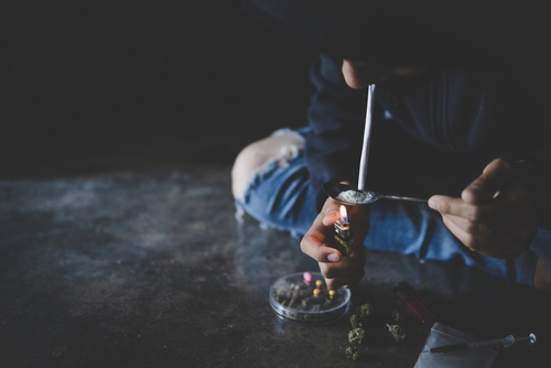 person sitting on floor while smoking meth