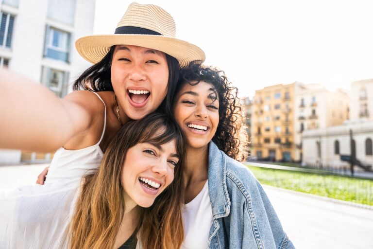 Three friends laugh together during their sober summer.