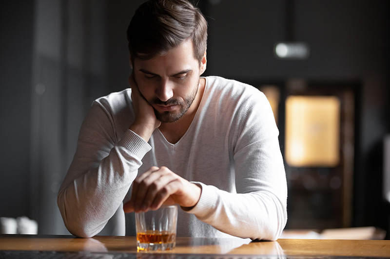 A man drinks an alcohol drink.