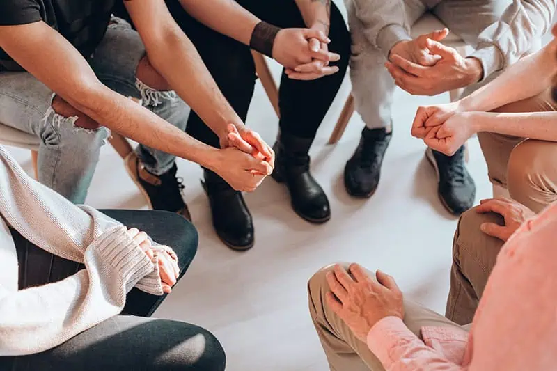 People participate in group therapy at a drug rehab center.